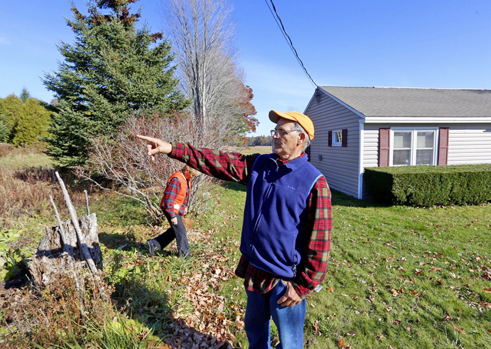 Dick Arsenault points to Turkey Lane in front of his house in Buxton, where a fatal car crash happened early Thursday morning. His wife, Elaine, is in the background. The couple say the body of a girl ended up in their side yard, only a few feet from their house.