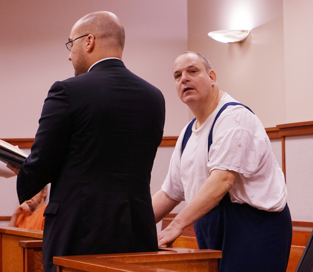 Steven Ricci, right, with his attorney, Mark Bullock, accepts new probation conditions in advance of his release from prison, in the Cumberland County Courthouse in Portland on Thursday.
