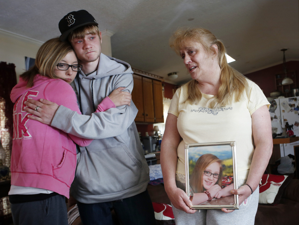 Christa Greene of Standish holds a framed photograph of her daughter, Angel Greene, who was killed in a car crash early Thursday. At left, family friend Ansley Moore, 27, of Hermon hugs Angel’s boyfriend, Nathan Buzynski, 17, of Dayton.