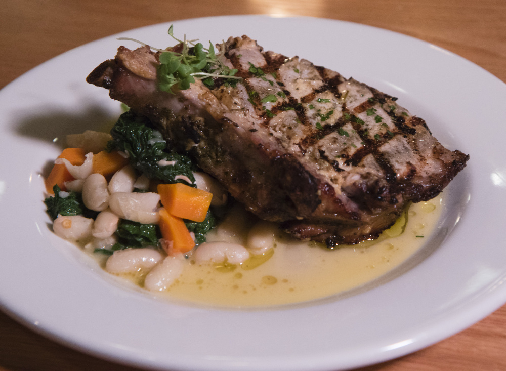 Grilled pork chop, served with cannellini beans, mustard greens and dijon.