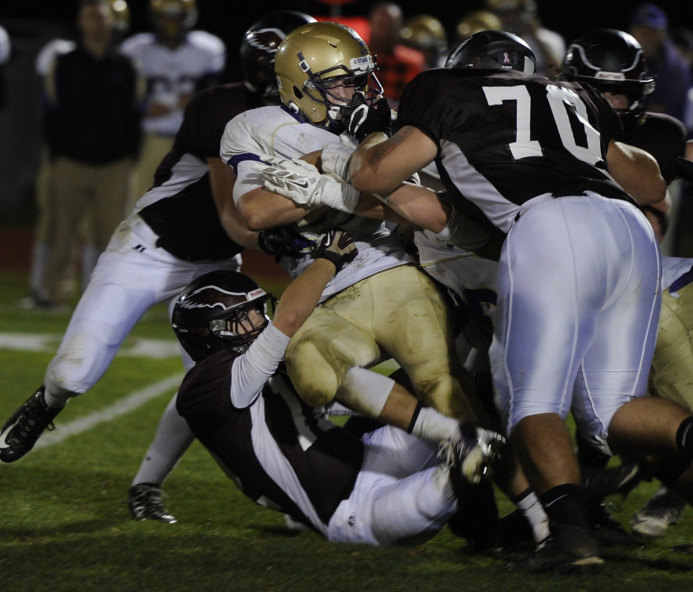 Windham’s defense tackles Cheverus’ Justin Johnson during the Eagles’ 28-0 win in a Class A North semifinal on Friday in Windham.
