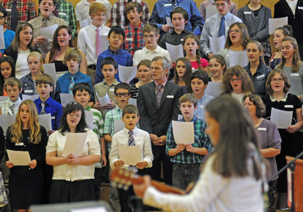 Students sing “This Land is Your Land” accompanied by classmate Emma Wadsworth during a naturalization ceremony Friday at Maranacook Community Middle School in Readfield.