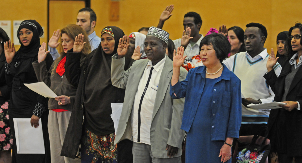 New American citizens take the Oath of Allegiance during a naturalization ceremony Friday at Maranacook Community Middle School in Readfield.