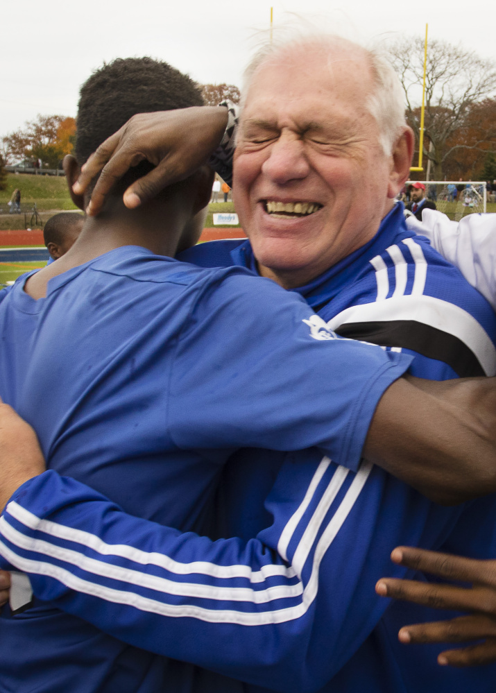 Lewiston Coach Mike McGraw, finishing his 33rd season with the Blue Devils, embraces his players after winning the state championship for the first time.