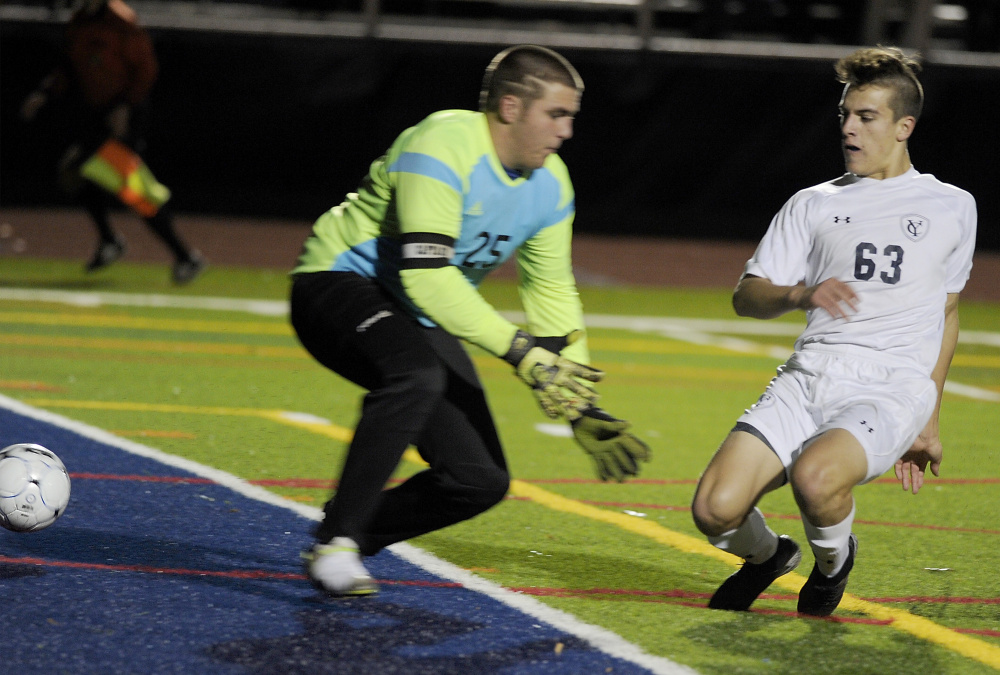 Walter Conrad slips the ball past Erskine Academy keeper Denver Cullivan for the first goal of the game Saturday, starting Yarmouth on its way to a 3-0 win in the Class B boys’ soccer state championship game at Fitzpatrick Stadium.
