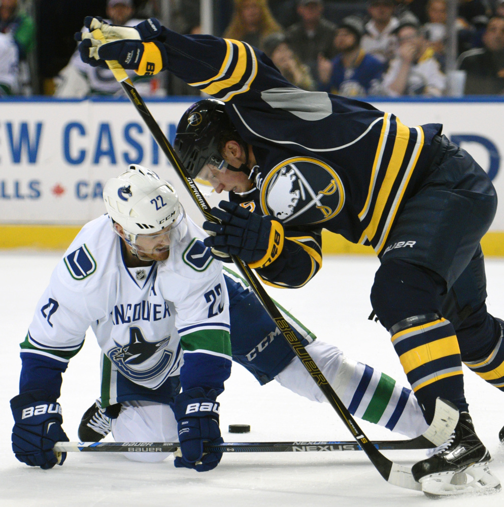 Canucks left wing Daniel Sedin, left, battles for the puck with Sabres rookie center Jack Eichel, right, during the second period Saturday in Buffalo. Eichel had two assists in the Sabres’ 3-2 win.