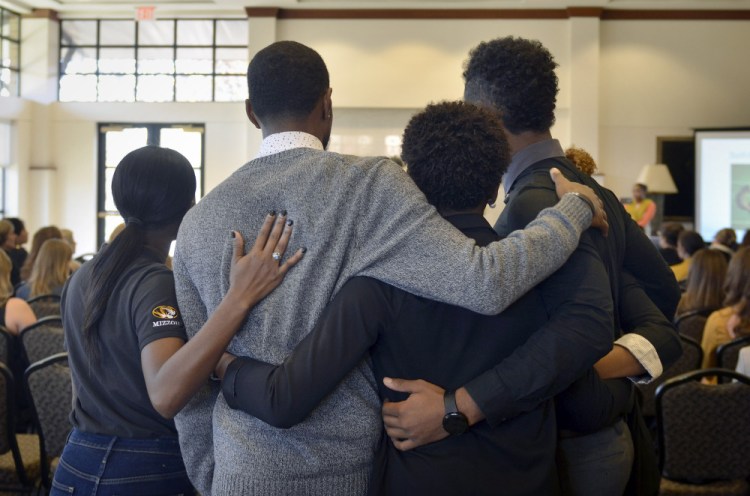 Members of the anti-racism and black awareness group Concerned Student 1950 embrace during a protest in the Reynolds Alumni Center on the University of Missouri campus in Columbia, on Saturday.