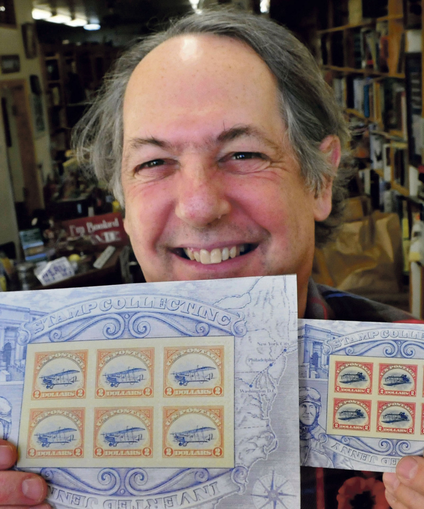 Robert Sezak  holds two versions of the reissued Jenny postage stamps on Monday. The copies at left show an upright Jenny aircraft and could be worth up to $60,000.
David Leaming/Morning Sentinel
