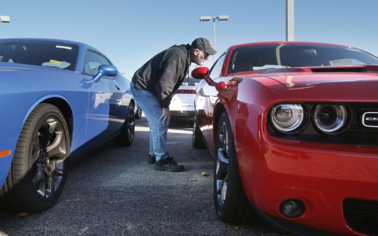 Bob Cournoyer of Lewiston checks out a Dodge Challenger at Lee Auto Mall in Westbrook on Monday. Challengers cost $30,000 to $40,000, representing some of the pricier models that Mainers have been leaning toward in 2015.