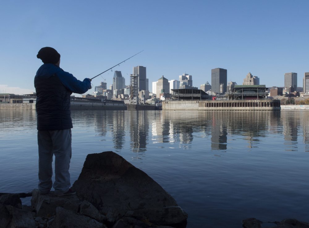 A man fishes on the shore of the St. Lawrence River Tuesday in Montreal. The city will begin a massive sewage dump Wednesday while it repairs its sewage infrastructure, putting 2.1 billion gallons of untreated sewage into the river during the process.