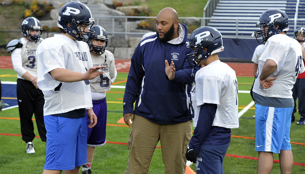 Eamon White, the line coach for Portland High, gives instructions to Nick Giaquinto, one of the five starting offensive linemen, during practice.