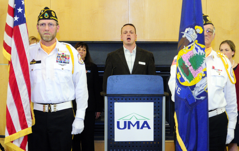 Nathaniel Grace, center, sings the national anthem while flanked by Kennebec County Veterans Honor Guard members Fred Line, left, and Normand Bernier during a veterans’ event Tuesday in the Randall Center at the University of Maine at Augusta.