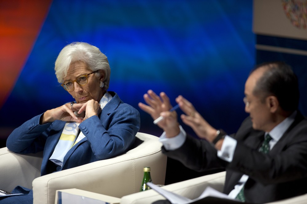 International Monetary Fund managing director Christine Lagarde listens as World Bank President Jim Yong Kim addresses a forum in Lima, Peru, on Oct. 7 during the annual meetings of the World Bank Group and IMF. Noting that the harm from China’s sharp economic downturn has been worse than expected, the IMF has downgraded its outlook for worldwide growth this year.