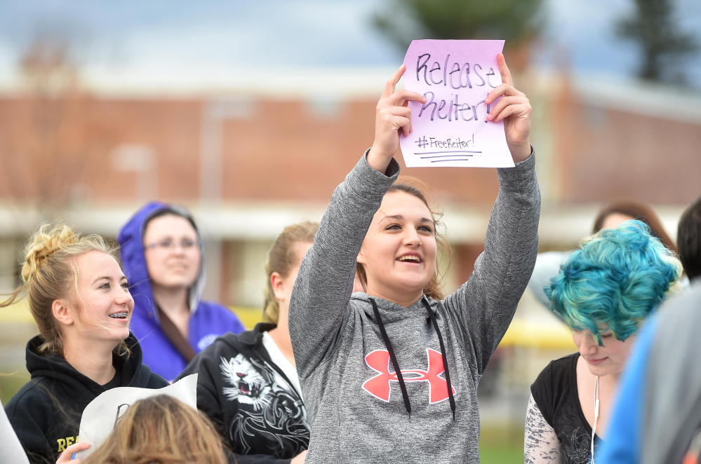 Amber Hill, 16, a junior at Waterville Senior High School, holds a sign in support of her principal, Don Reiter, at a support rally at the school on Friday.