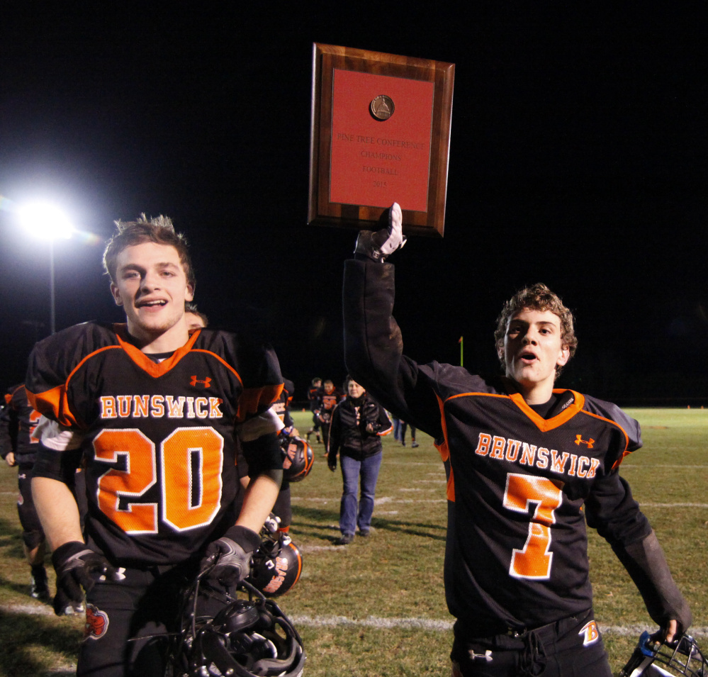 Jesse Devereaux, right, and Hunter Garrett show off the championship plaque after Brunswick captured its second straight regional football title Friday night with a 49-0 victory over Brewer in the Class B North final.