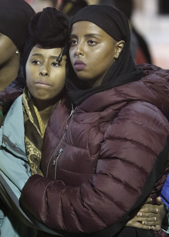 Naj Abdullahi, left, and Ifrah Hassan listen to a speaker during Friday night's rally in Monument Square. Abdullahi is a sophomore at Waynflete School in Portland and Hassan is a junior at Deering High.