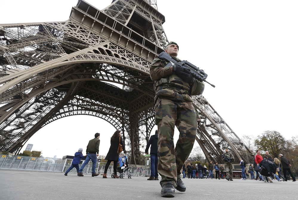 The French military patrols Saturday near the Eiffel Tower, a day after terrorist attacks at seven sites in Paris killed 129 people and injured 352 more. All seven attackers died: six in suicide blasts while the seventh was shot by police.