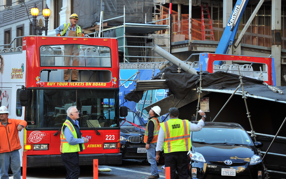MUNI workers assess the scene of a crash near Union Square in San Francisco on Friday.