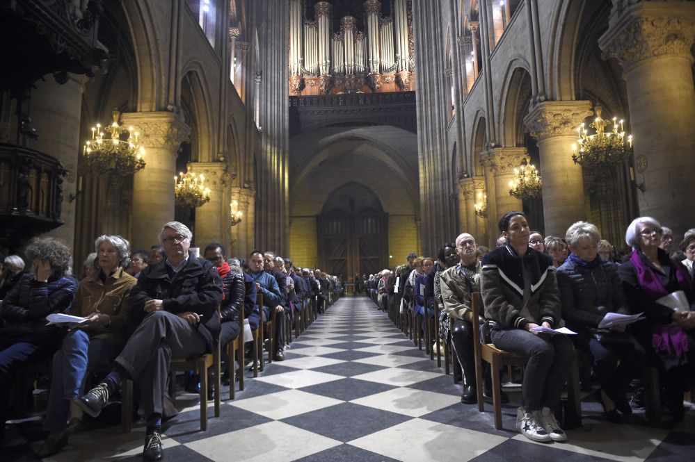 People attend a mass in homage to terrorist attack victims at the Notre Dame cathedral in Paris Sunday.