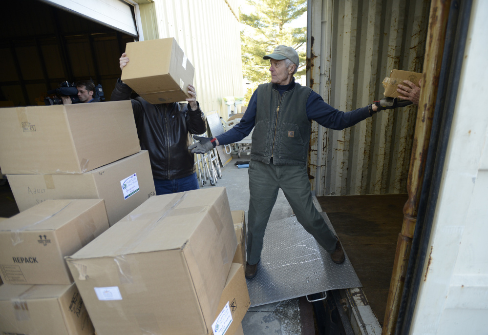 John Nolan passes a box into a truck as Partners for World Health prepare to ship out over 900 boxes of needed medical supplies to Syria on Monday. The South Portland nonprofit began in Elizabeth McLellan’s home in 2007.