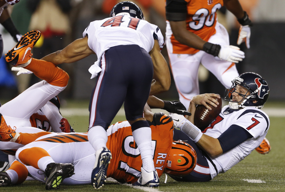 Texans quarterback Brian Hoyer, right, is sacked by Bengals outside linebacker Vincent Rey in the first half of the Texans’ 10-6 win Monday in Cincinnati. It was the Bengals’ first loss of the season.