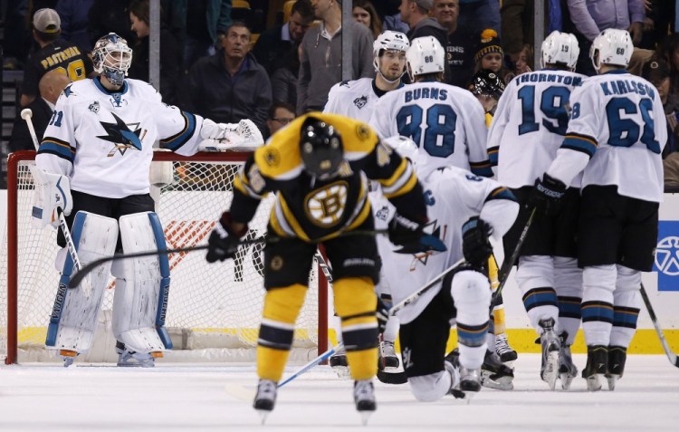 The Sharks’ Martin Jones, left, stands in the net as the Bruins’ David Krejci, foreground center, skates away while the Sharks celebrate their 5-4 win over Boston on Tuesday night.