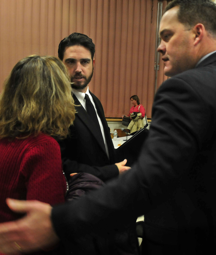 Don Reiter, center, is consoled by a woman and his lawyer, Gregg Frame, following Monday’s vote by the Board of Education to fire him as principal of Waterville Senior High School.