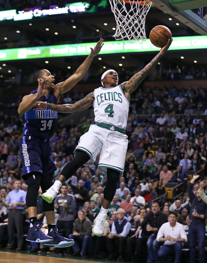 Celtics guard Isaiah Thomas flies past Mavericks guard Devin Harris on a layup in the first quarter. Boston’s three-game winning streak ended with a 106-102 loss to Dallas.