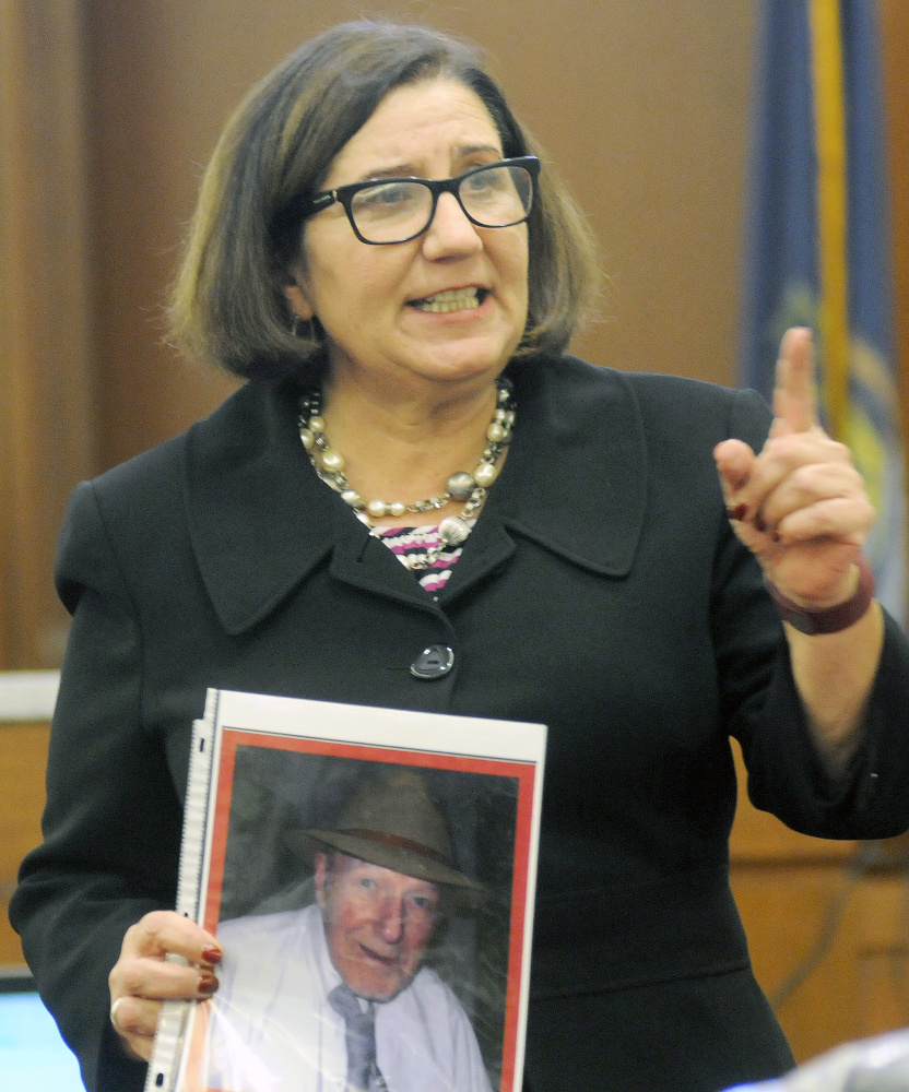 Assistant Attorney General Leane Zainea holds a photo of murder victim Aurele Fecteau Wednesday during closing arguments of the trial of Roland L. Cummings in Augusta.