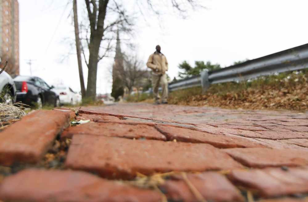 A pedestrian makes his way along the uneven brickwork between Pearl and Franklin streets in Portland.