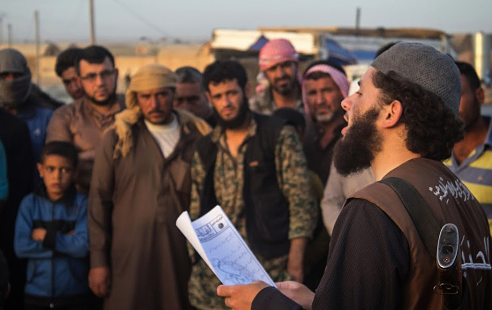 In photo from a militant website, a member of the Islamic State’s vice police, right, reads a verdict handed down by an Islamic court in Raqqa, Syria. Some analysts expect the Islamic State to launch more attacks abroad to divert attention from its recent losses.