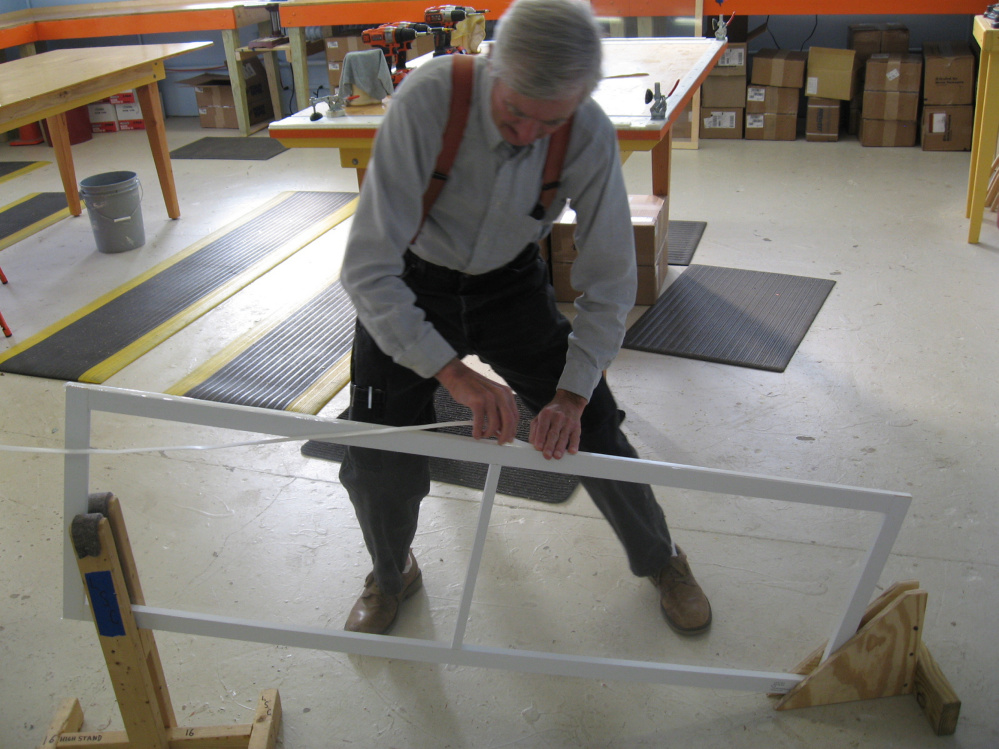 The humble Farmer helps build a reusable interior storm window at the Rockland plant of the nonprofit Window Dressers.