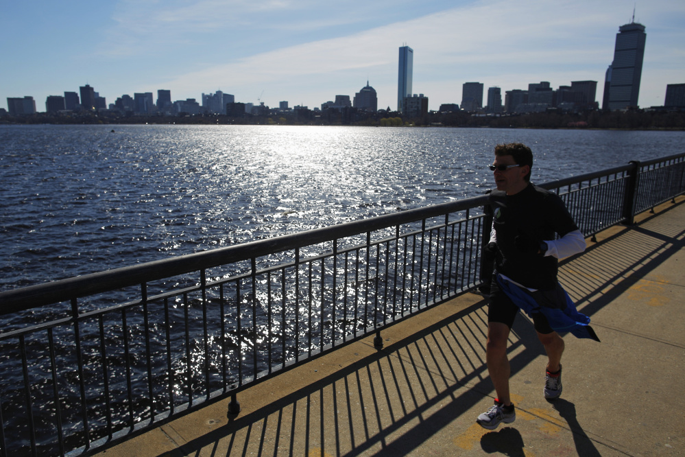 A jogger runs across Harvard Bridge past the Boston skyline in Cambridge, Mass. The state capital fared well in a real estate analysis that found a widening economic gap in neighborhoods in most U.S. cities.