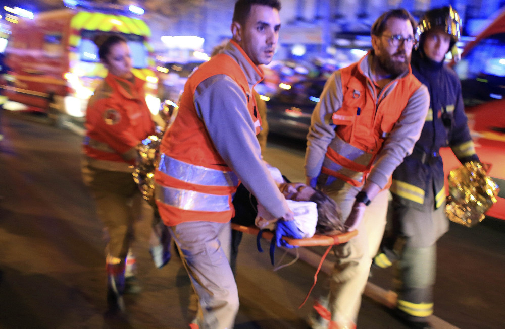 A woman is evacuated after the Nov. 13 attack in Paris. As of Wednesday, 195 people were still hospitalized.