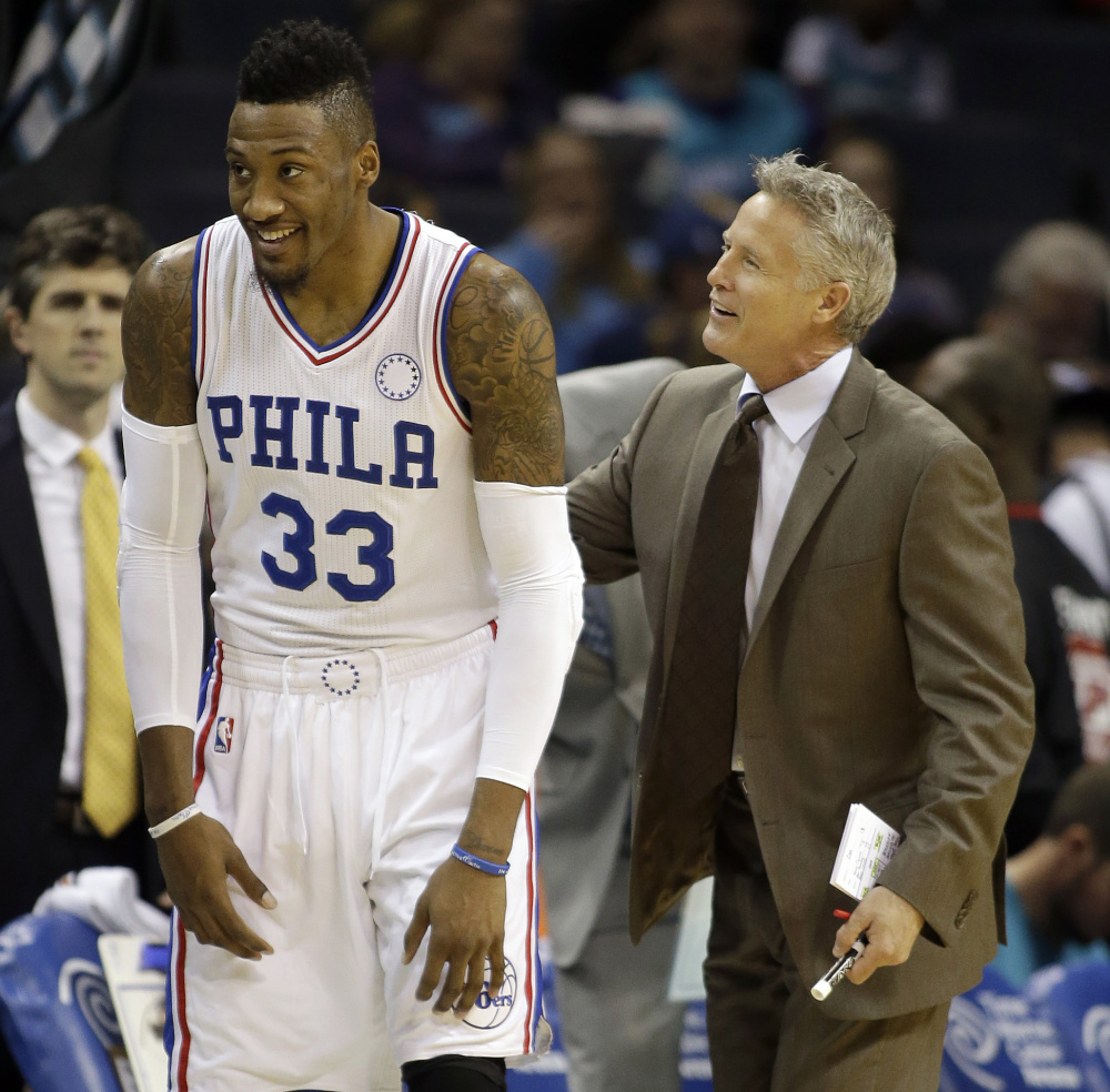 Philadelphia Coach Brett Brown, a South Portland native, talks to Robert Covington during the 76ers’ 113-88 loss Friday night at Charlotte. The Sixers are 0-13.