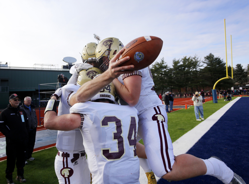 Thornton Academy quarterback Austin McCrum has the football and the joy of his teammates after scoring the fourth-quarter touchdown that put the game away.