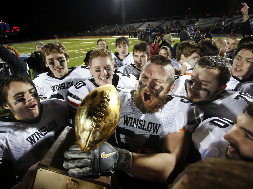 Alex Clark, a four-year starter, hoists the Gold Ball as he and his Winslow teammates celebrate another Class C state championship.