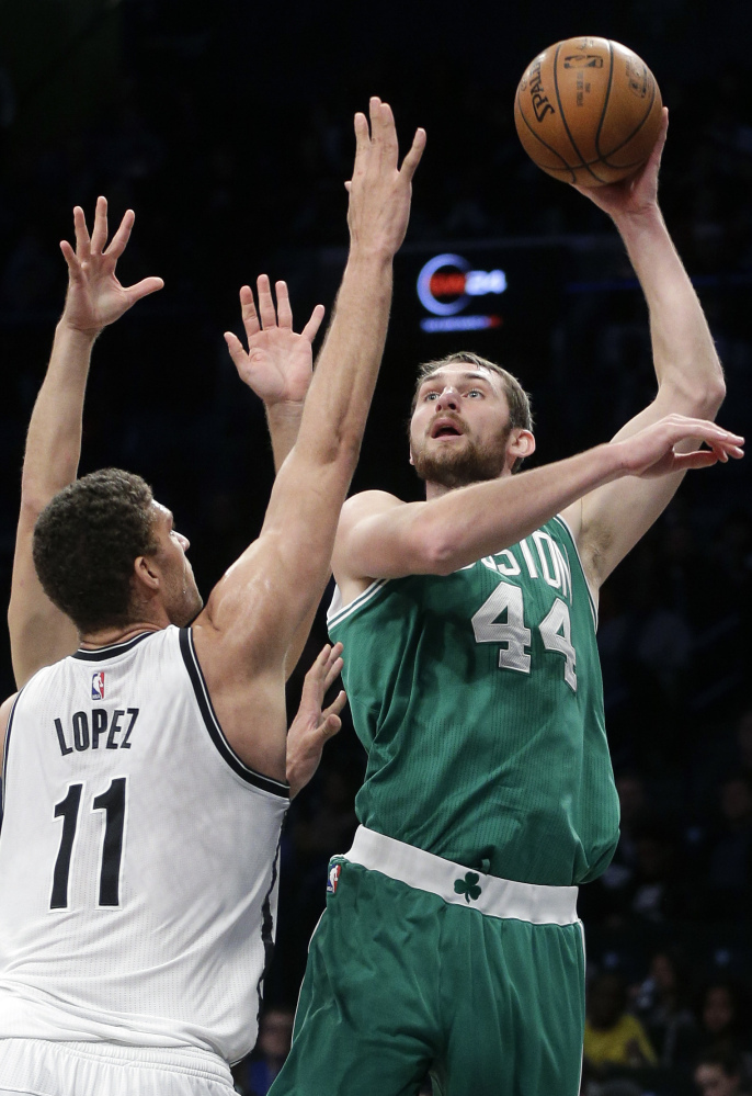 Boston’s Tyler Zeller, right, takes a shot while being defended by Brooklyn’s Brook Lopez on Sunday in New York. Lopez scored 23 points and the Nets won 111-101.