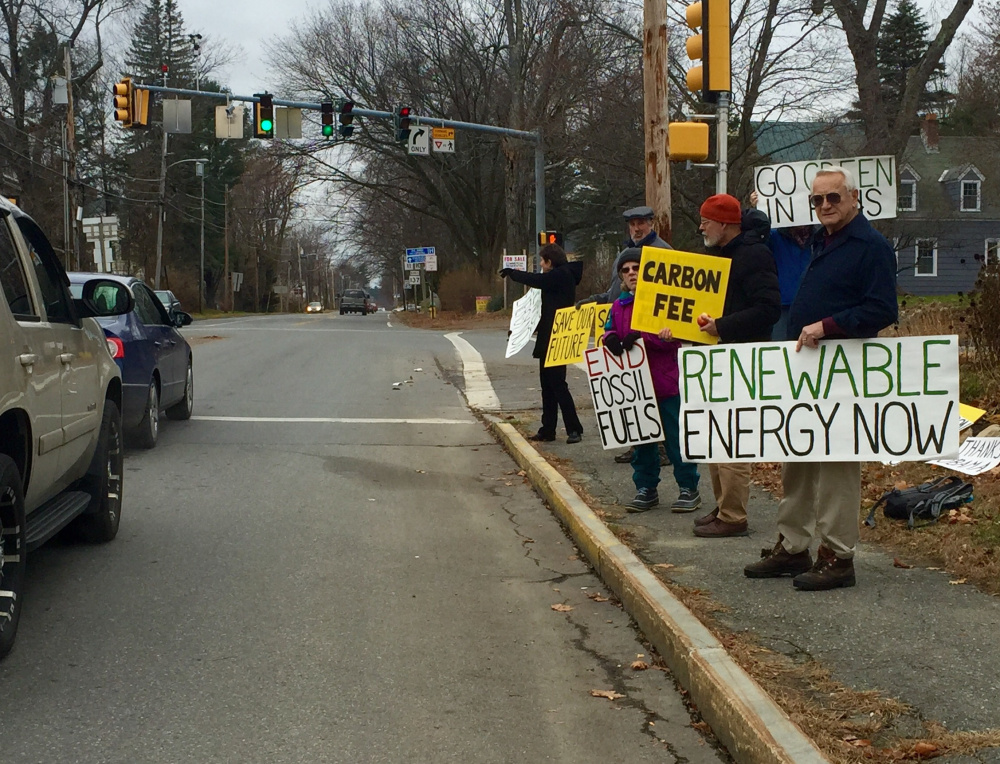 Members of 350 Central Maine demonstrate along Silver Street in Waterville in front of the Universalist Unitarian Church to promote climate change awareness.