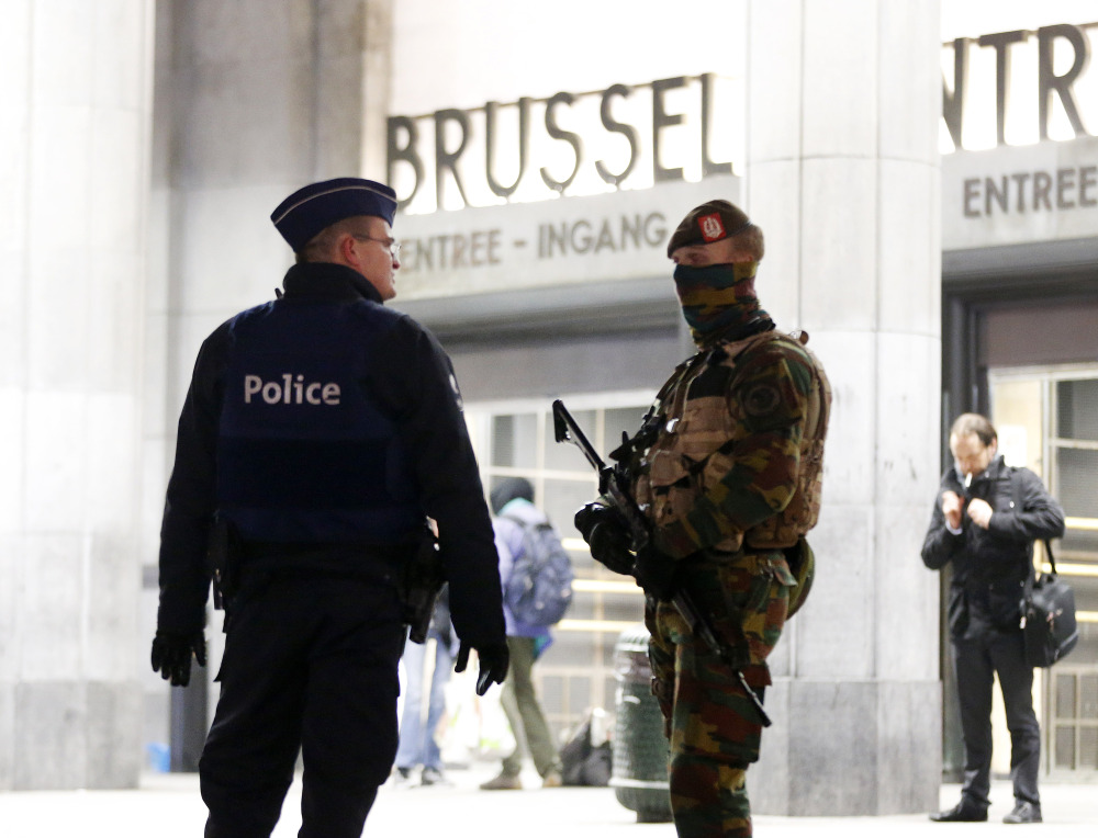 Belgian police officers check in with each other in front of the central station in downtown Brussels on Monday. The capital was in its third day of lockdown, with schools and underground transport shut and more than 1,000 security personnel deployed across the country.