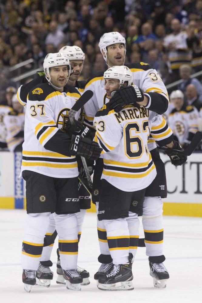 Brad Marchand is congratulated by Patrice Bergeron, left, Adam McQuaid and Zeno Chara, right, after scoring for the Bruins in the first period.