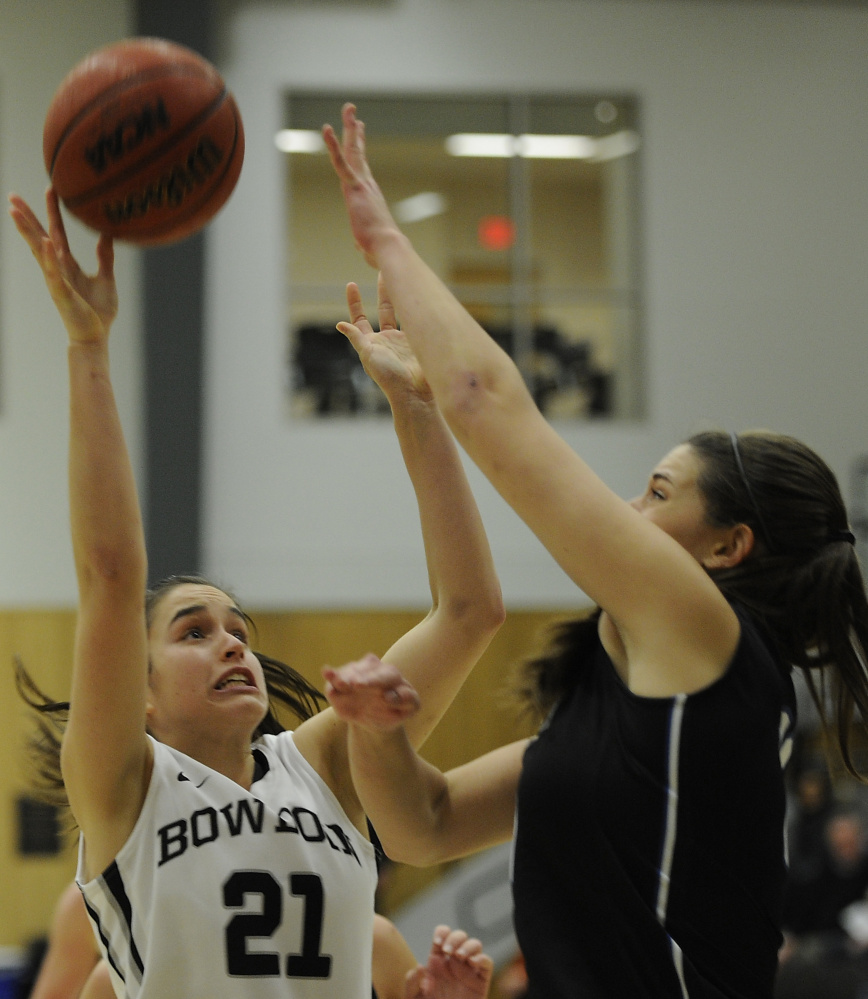 Ally Silfen of Bowdoin puts up a rebound Tuesday night while defended by Alicia Brown of the University of New England during UNE’s 66-46 victory at Bowdoin.