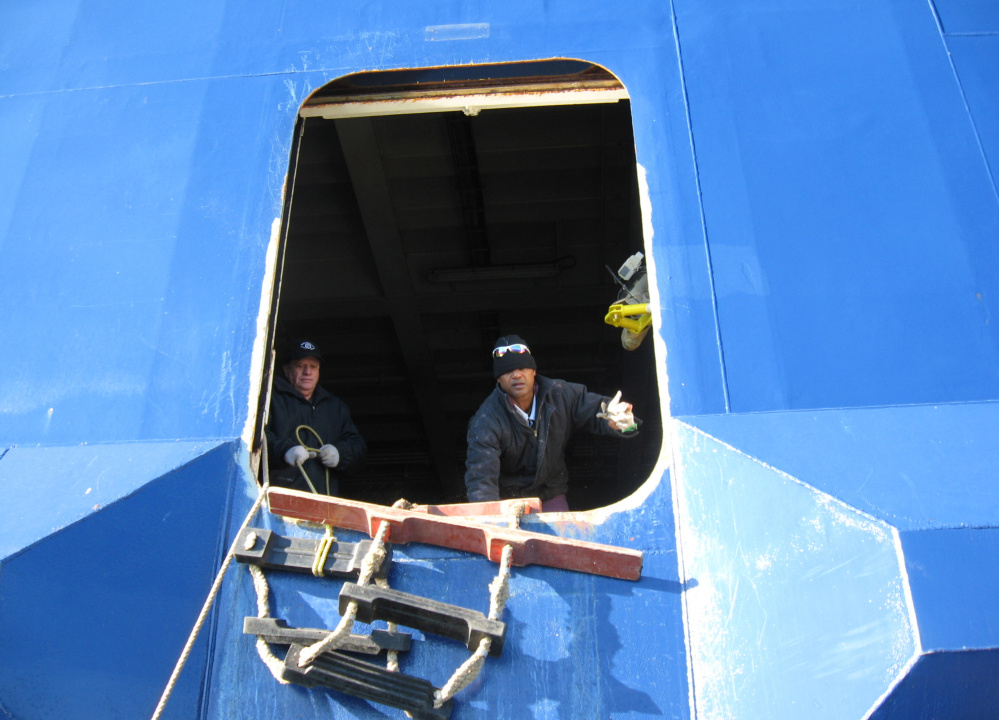 Crew members aboard the Nova Star on Wednesday receive two pallets of food supplies delivered by boat. The vessel is anchored in Portland Harbor near Fort Gorges.