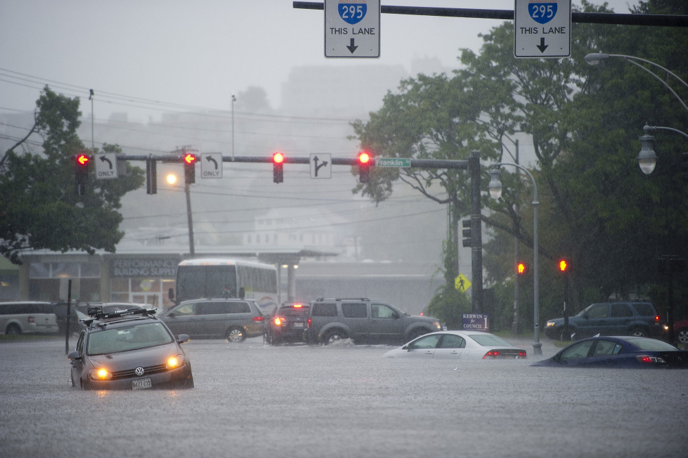 Disabled cars sit in high floodwaters at Franklin and Somerset streets in Portland during a deluge in September that coincided with a king tide.