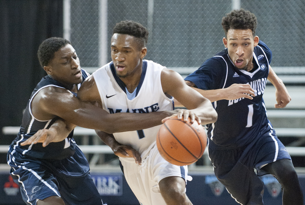 UMaine’s Aaron Calixte brings the ball up the floor with pressure from Longwood’s Bryan Gee, left, and Leron Fisher on Wednesday at the Cross Insurance Center in Bangor. UMaine won, 92-82.