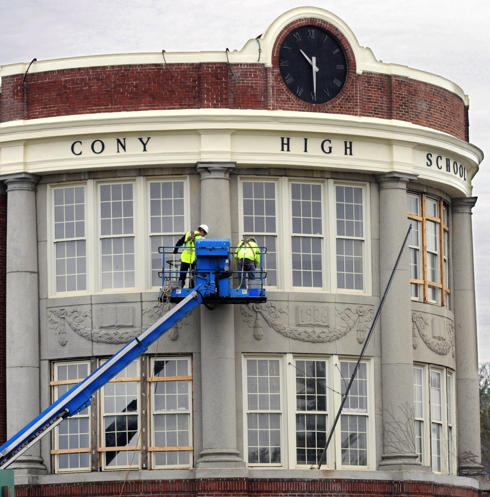 Construction workers high on a lift above Cony Circle in October 2014 work on windows of the curved facade of the former Cony High School flatiron building in Augusta. The 1926 building was converted into senior citizens’ housing, a project honored by Maine Preservation last week.