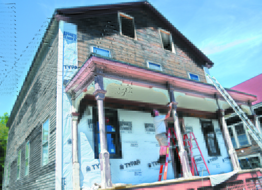 Mark Curtis, of Guyon & Sons Painting, coats trim on the porch of the former Hallowell Granite Works office building in 2013 in Hallowell. The renovation of the building, owned by Jim Duncklee and Ken Knott, was honored by Maine Preservation last week, one of 16 in the state recognized by the organization.