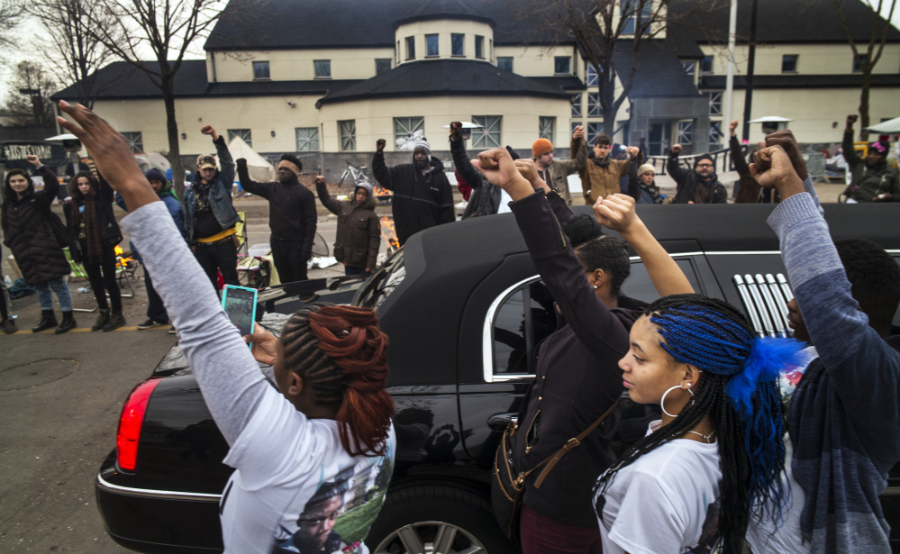 Family members of Jamar Clark show support for Black Lives Matter demonstrators as Clark’s funeral procession passes the Minneapolis 4th Precinct police station on Wednesday. Clark was fatally shot Nov. 15 in a scuffle with police.