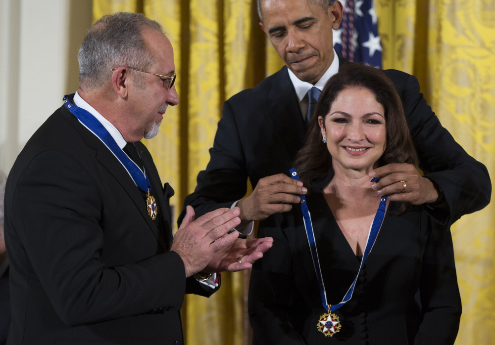 Emilio Estefan watches President Obama present the Presidential Medal of Freedom to his wife, Gloria Estefan, at the White House Tuesday. Both Estefans got medals.
