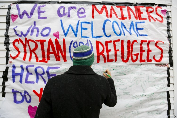 This sign on Congress Street drew together in a memorable encounter several people concerned about refugees’ plight, a reader writes.